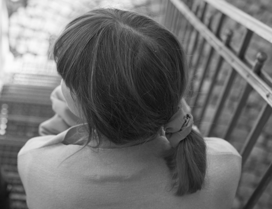 Schnappschuss von einer Mittarbeiterin von hinten auf der Treppe sitzend