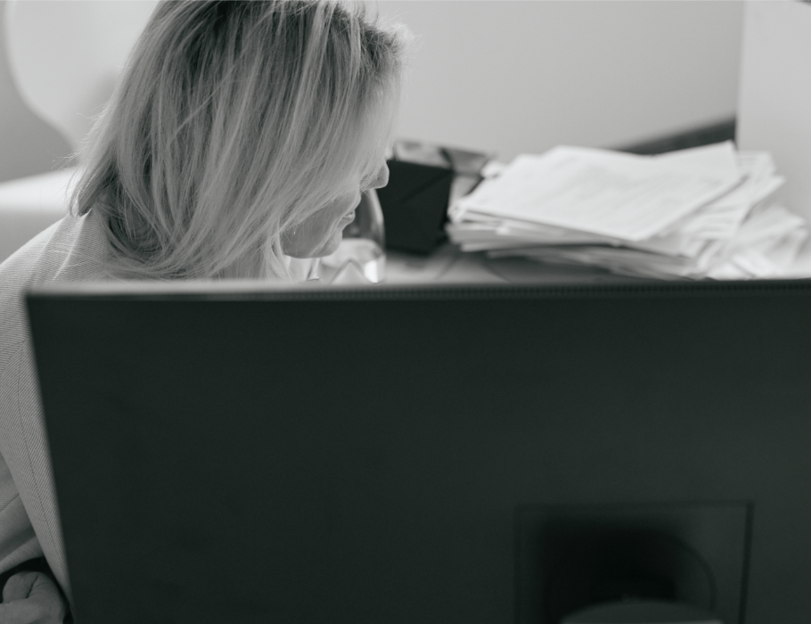 Mitarbeiterin von Hinten am Schreibtisch sitzend